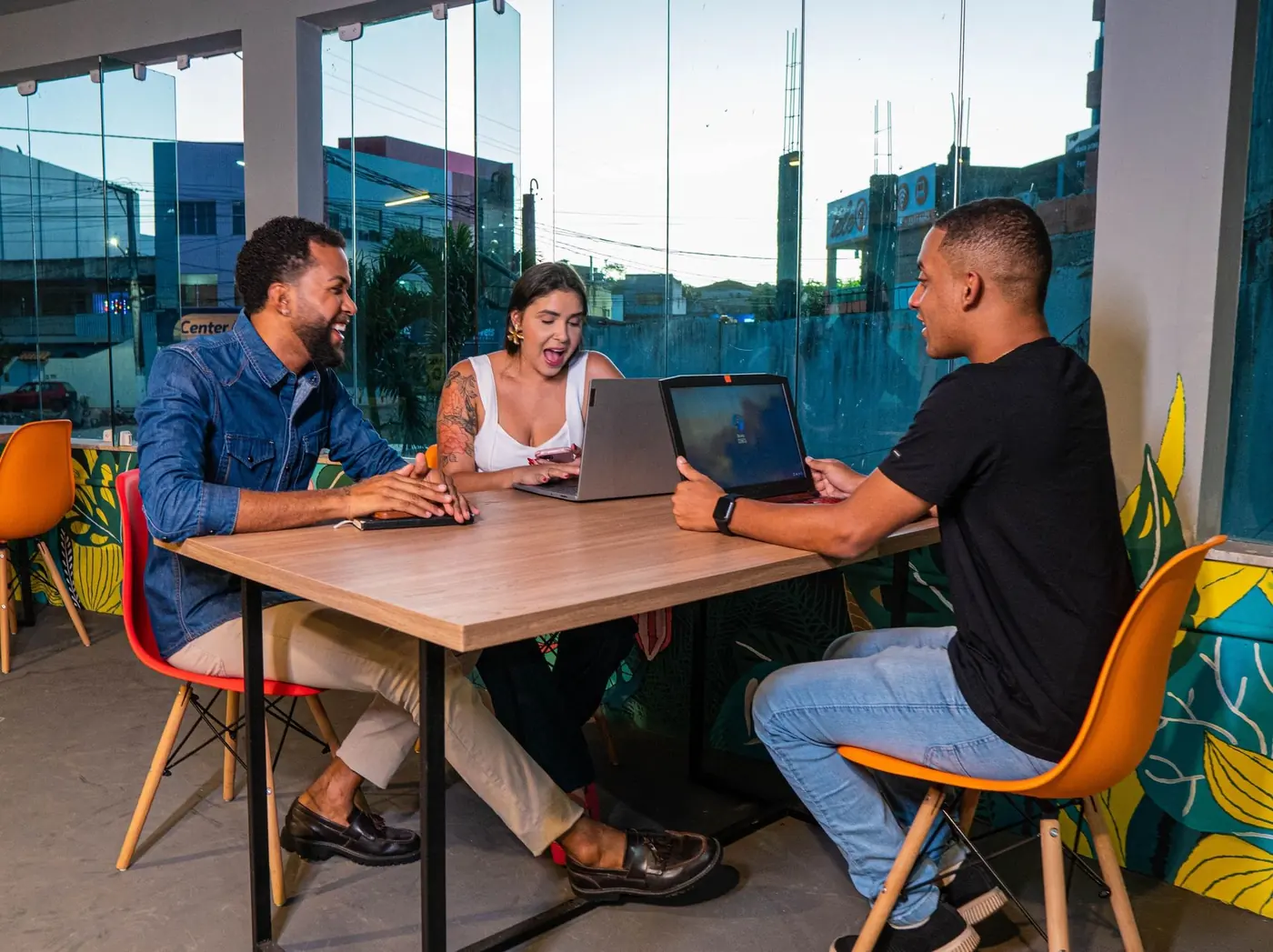 Three students working together on laptops at a table